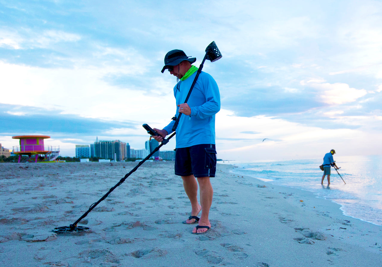 Persoon die metaaldetector gebruikt op het strand